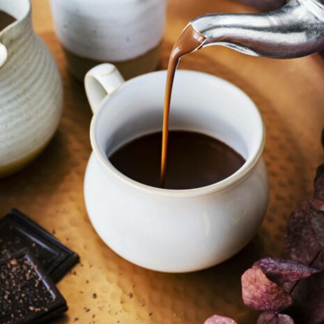 Pouring hot chocolate from a kettle food photography